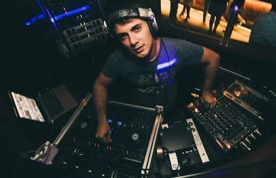 Produtor da Fita Cassete, de fones de ouvido, tocando em uma controladora de DJ